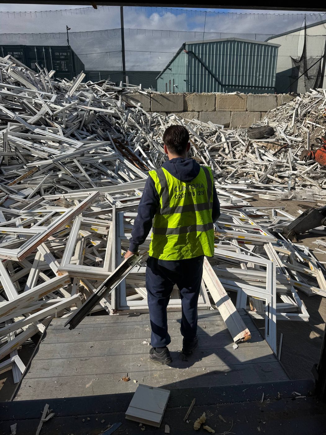 Collection crew handling uPVC frames at the reprocessing yard